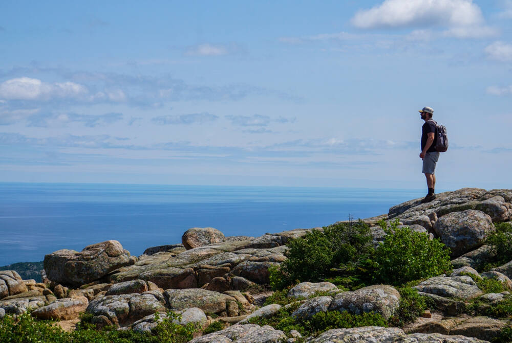 A hiker looks out over the Atlantic Ocean