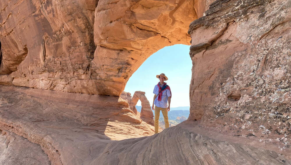 A young hiker enjoys exploring the arches national park's many arches during a warm summer day