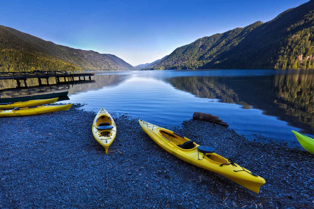 Kayaks lining the rocky shoreline of Lake Crescent
