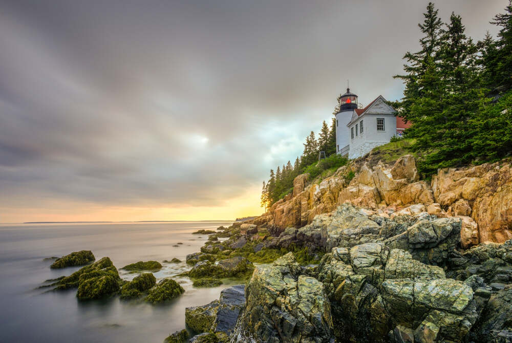 A dramatic stormy sunset along the Bass Harbor Head Lighthouse in acadia national park