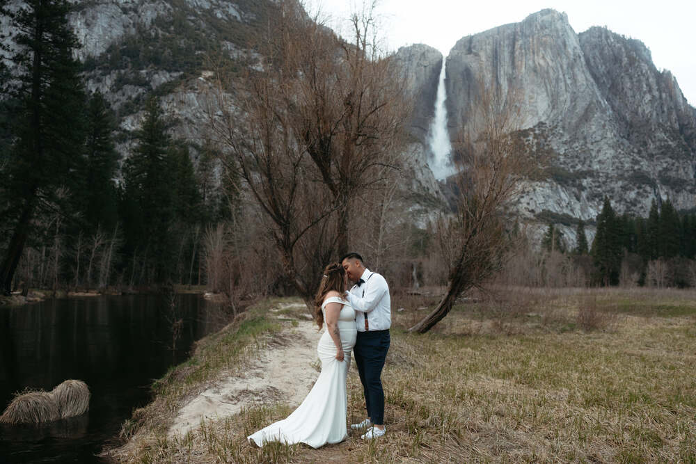a wedding couple posing in front of the iconic Yosemite Falls