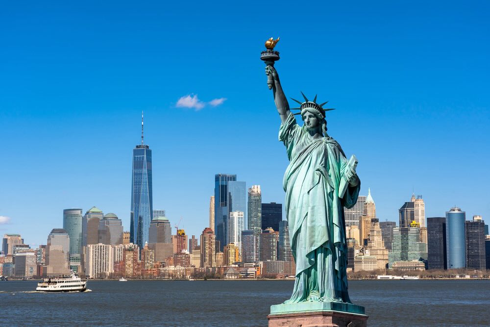 statue of liberty in new york with new york city skyline in background