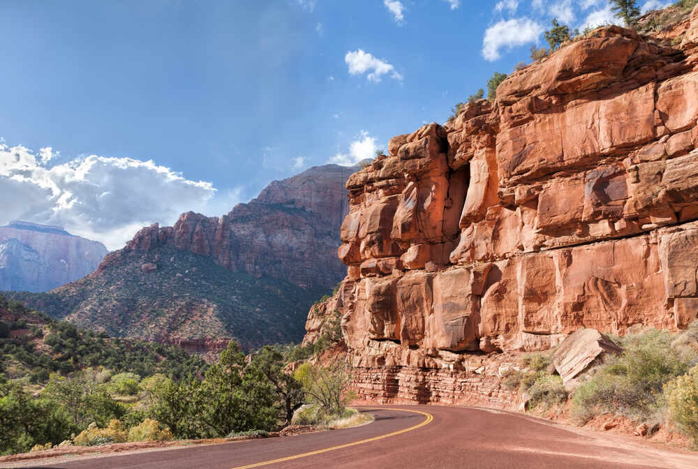 Zion Canyon Scenic Drive  with stunning red cliffs in the foreground and mountain landscape in the background