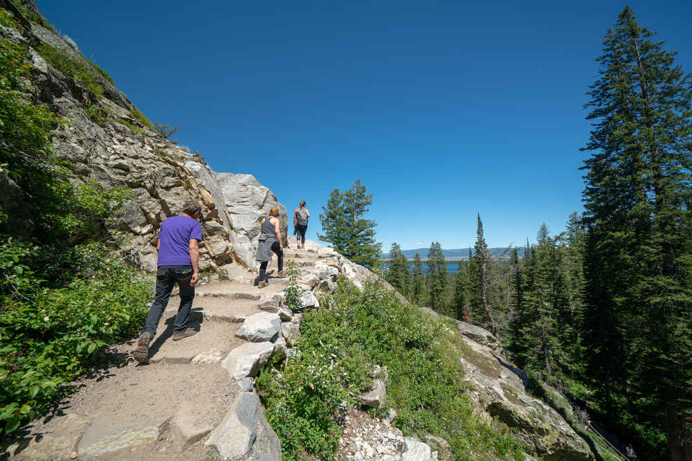 A group of hikers trek through Cascade Canyon Trail to Hidden Falls